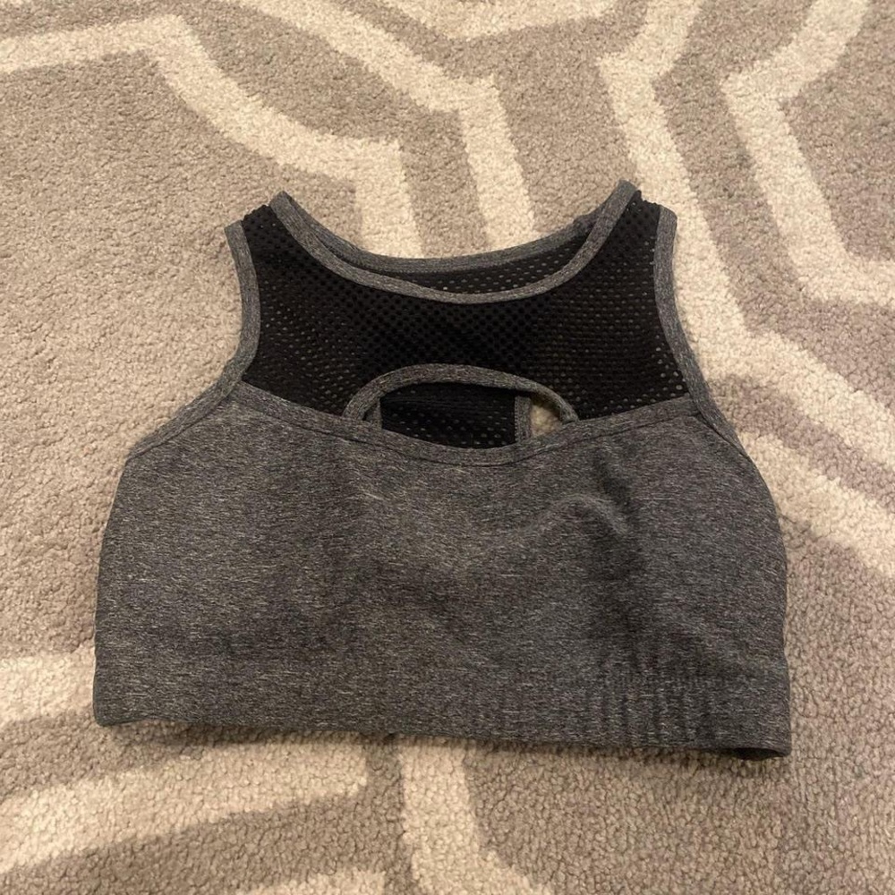 charcoal grey sports bra with black mesh netting.